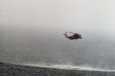 A right side view of a Helicopter Mine Countermeasures Squadron 14 (HM-14) RH-53D Sea Stallion helicopter towing a lightweight magnetic sweep during mine contermeasures operations. The helicopter is assigned to the amphibious assault ship USS GUAM (LPH 9). Note: Fourth view in a series of six