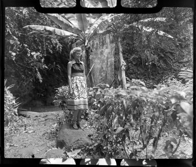 Paulette, standing on a rock near native plants and trees, Tahiti