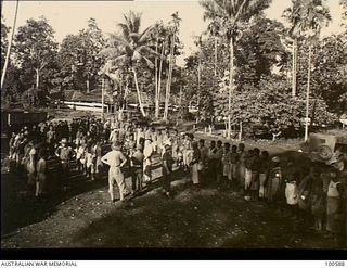 Lae, New Guinea. c. 1944-07-25.Major H. E. Gale, Camp Commandant, and his assistant Captain C. F. Brady, HQ New Guinea Force, allotting native boys to their respective daily tasks