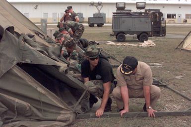 US Air Force Technical Sergeant Mike McMullan, 36th Civil Engineer Squadron, Andersen Air Force Base, Guam, and US Navy Commander Larry Macias, Navy Public Works, Naval Station Diego Garcia, raise a tent which will house airmen assigned to the 96th Bomb Squadron and support personnel from the 2nd Bomb Wing, Barksdale Air Force base, Louisiana. The airmen are deployed to Naval Station Diego Garcia in support of Operation DESERT THUNDER 2