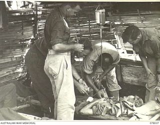 BOUGAINVILLE ISLAND. 1944-12-31. Q22061 SERGEANT O.W. WREN, 25TH INFANTRY BATTALION WHO WAS WOUNDED DURING THE AUSTRALIAN ATTACK ON JAPANESE POSITIONS IN THE PIATERAPAIA SECTOR, RECEIVING A BLOOD ..