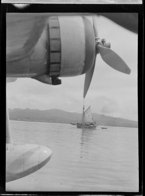 Sailing ship in harbour, with Tasman Empire Airways Ltd Short Empire flying boat 'Aotearoa' ZK-AMA in foreground, Suva, Fiji