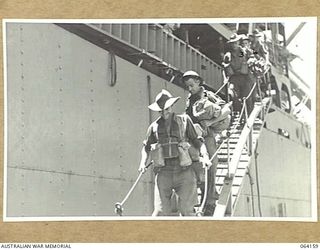 TOWNSVILLE, QLD. 1944-01-28. PERSONNEL OF THE 2/28TH INFANTRY BATTALION, PROCEEDING DOWN THE GANGWAY OF THE TROOPSHIP, "VAN HEUTSZ" ON THEIR RETURN HOME FROM NEW GUINEA. IDENTIFIED PERSONNEL ARE:- ..