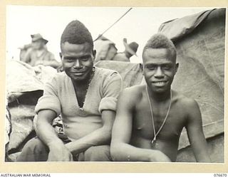 JACQUINOT BAY, NEW BRITAIN. 1944-11-04. TWO NATIVE BOYS, ONE FROM NEW BRITAIN AND ONE FROM NEW IRELAND, WHO WERE HOUSEBOYS FOR LIEUTENANT-COLONEL A.T. ALLAN, 5TH BASE SUB AREA, ARE HAPPY TO BE ON ..