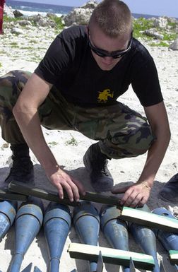 SENIOR AIRMAN (SRA) Adam Ginett of the 36th Explosive Ordnance Disposal (EOD) flight, Andersen Air Force Base (AFB), Guam, prepare to detonate ordnance on the Tarague EOD range, by laying blocks of C 4 explosives over MK 76 Marine practice bombs