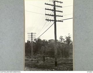 LAE, NEW GUINEA. 1944-04-03. NX86574 SIGNALMAN R. BYRNE (1), AND WX8229 CAPTAIN J.A. PRESCOTT (2), MEMBERS OF THE 19TH LINES OF COMMUNICATION SIGNALS ALONGSIDE THE LAE TELEPHONE ROUTE ON THE NADZAB ..