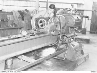 LAE, NEW GUINEA. 1944-06-09. WX15056 CORPORAL T.G. ELIOT (1), OPERATES A LONG BED LATHE IN THE GENERAL ENGINEERING SHOP AT THE 2/7TH ADVANCED WORKSHOP