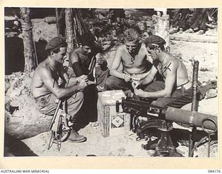 BOUGAINVILLE, SOLOMON ISLANDS. 1944-12-09. AUSTRALIANS OF THE 15 INFANTRY BATTALION, 29 INFANTRY BRIGADE, PLAYING CARDS WITH MEMBERS OF THE 182 INFANTRY REGIMENT, UNITED STATES ARMY IN A MACHINE ..