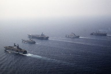 Ships from four nations sail in formation during the NATO Southern Region exercise Dragon Hammer '90. The ships are, from left: the amphibious assault ship USS SAIPAN (LHA-2), the Spanish aircraft carrier SPS PRINCIPE DE ASTURIAS (R-11), the nuclear-powered aircraft carrier USS DWIGHT D. EISENHOWER (CVN-69), the Italian light aircraft carrier ITS GIUSEPPE GARIBALDI (C-551) and the British light aircraft carrier HMS INVINCIBLE (R-05)