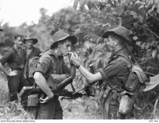 A FORWARD OBSERVATION PATROL FROM C COMPANY, 2/1 INFANTRY BATTALION RESTING AFTER STRIKING LEVEL GROUND ONCE MORE. IDENTIFIED PERSONNEL ARE:- PTE P.K. DUNLOP, BREN GUNNER (1); CPL J. SELLIN, OWEN ..