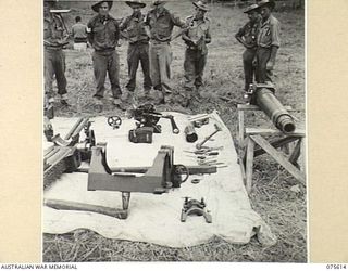 MARKHAM VALLEY, NEW GUINEA. 1944-08-28. A GENERAL VIEW OF A DISMANTLED SHORT 25 POUNDER GUN WITH THE GUN CREW FROM 12 BATTERY, 4TH REGIMENT, IN THE BACKGROUND. IDENTIFIED PERSONNEL ARE: VX68868 ..