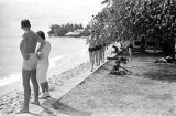 Guam, men walking along beach