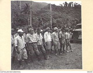 KAIRIRU ISLAND, NEW GUINEA, 1945-09-08. JAPANESE SOLDIERS ON PARADE ALONGSIDE THE WEAPON DUMP AWAITING COMMAND TO COMMENCE LOADING WEAPONS ON HQ 6 DIVISION TRUCKS. STAFF OFFICERS OF HQ 6 DIVISION ..