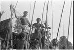 Men on platform presenting shell money at mortuary feast