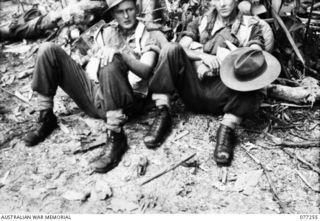 BOUGAINVILLE ISLAND, 1944-11-23. NX102916 PRIVATE M.J. DORE (1) AND N155920 PRIVATE G.V. WATT (2) D COMPANY, 9TH INFANTRY BATTALION ENJOYING A REST AFTER CLIMBING A STEEP SECTION OF THE PIATERAPAIA ..