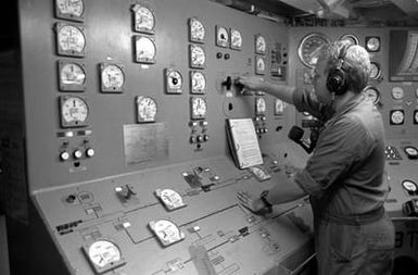 A sailor in an engineering space aboard the amphibious assault ship USS SAIPAN (LHA 2) makes an adjustment to the ship's electrical generating system. The SAIPAN is on station off the coast of Liberia for Operation Sharp Edge