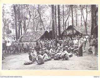 KUMUIA YAMA, RABAUL AREA, NEW BRITAIN. 1945-09-17. EMACIATED INDIAN TROOPS STANDING AND SITTING ABOUT THE CAMP LIVING QUARTERS OF THE INDIAN PRISONER OF WAR CAMP. THE MEN WERE LIBERATED BY ..