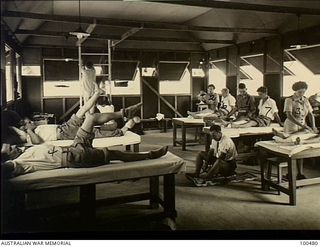 Port Moresby, New Guinea. 1944-05-29. The interior of the Physiotherapy Department at 128th Australian General Hospital, showing physiotherapists working with patients. Left side: front to back: ..