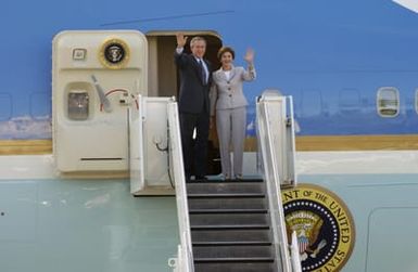US President George W. Bush and his wife Laura, wave to a well wishing crowd as they step off US Air Force (USAF) Air Force One (VC-25), a Boeing 747 passenger aircraft at Hickam Air Force Base (AFB), Hawaii (HI), near Base Operations during a visit