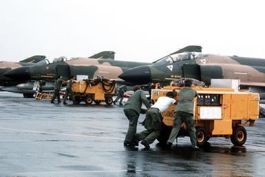 A maintenance crew moves M-32 A-60 generators into position to service F-4 Phantom II aircraft during a rest stop. The equipment is being used during redeployment of F-4's of the 34th Tactical Fighter Squadron from Korat Royal Thai Air Force Base, Thailand, to the United States because of a reduction in forces