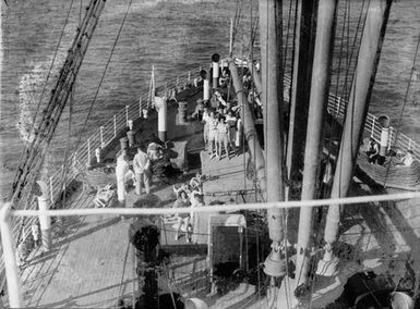 [People waving on the foredeck of a cruise ship]