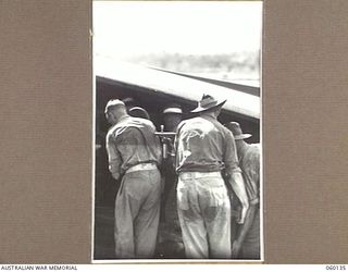 WARD'S DROME, NEW GUINEA. 1943-11-16. TROOPS OF THE 2/5TH AUSTRALIAN FIELD REGIMENT, 7TH AUSTRALIAN DIVISION LOADING A DISMANTLED LONG 25-POUNDER GUN INTO A DOUGLAS TRANSPORT AIRCRAFT, DURING AN ..