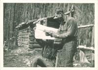 Expedition member Robert A. Brown with dead pack rat in Washington state, The University of Iowa, 1920
