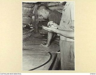 MOTUPINA POINT, BOUGAINVILLE ISLAND. 1945-01-19. VX87706 BOMBARDIER J. BELL, 2ND FIELD REGIMENT, TARGET PLOTTING IN THE NO. 5 BATTERY COMMAND POST