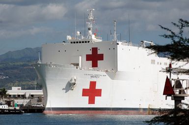 A port bow view of the US Navy (USN) Military Sealift Command (MSC) Hospital Ship, USNS MERCY (T-AH 19) conducting re-supply operations while moored to the pier at Naval Base Pearl Harbor, Hawaii (HI), for a brief port visit prior to deploying to Southeast Asia to provide assistance to victims of the devastating Tsunami that hit the region in support of Operation UNIFIED ASSISTANCE