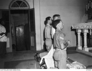 PORT MORESBY, PAPUA, 1944-02-20. THE PRIEST PICTURED WITH SERVERS DURING THE SERVICE IN THE ROMAN CATHOLIC CHURCH. THE CHURCH IS WELL PATRONIZED BY BOTH AUSTRALIAN AND AMERICAN SERVICEMEN