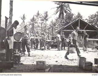 NAGADA, NEW GUINEA. 1944-09-11. THE MESS PARADE OF THE 5TH FIELD COMPANY, IN PROGRESS AT THE UNIT CAMP. IDENTIFIED PERSONNEL ARE: N51421 CORPORAL C.W. JOLLY (1); NX157138 SERGEANT W.R. MCINTYRE ..