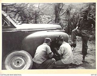 RABAUL, NEW BRITAIN. 1945-09-26. JAPANESE MECHANICS WORKING IN AN AUSTRALIAN CAMP AT THE VISITORS' AND OBSERVERS' SECTION ON A CAR WHICH WAS COMMANDEERED FROM THE JAPANESE AND WILL NOW BE USED BY ..