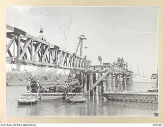 SOUTH BOUGAINVILLE, 1945-05-27. THE SAVIGE BRIDGE OVER THE JABA NO. 1 RIVER ALMOST COMPLETED. CONSTRUCTED BY MEMBERS OF 11 FIELD COMPANY ROYAL AUSTRALIAN ENGINEERS, IT WAS COMPLETED IN FIVE WEEKS ..