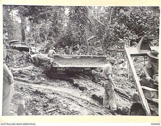 SOUTH BOUGAINVILLE. 1945-07-29. TROOPS OF 15 FIELD COMPANY, ROYAL AUSTRALIAN ENGINEERS, FREEING A BULLDOZER WHICH IS BOGGED ON THE BUIN ROAD BY MEANS OF A POWER WINCH ATTACHED TO ANOTHER BULLDOZER. ..