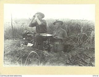 BULATAGI, NEW GUINEA. 1944-07-31. OBSERVATION POST OFFICER, NX71707 LIEUTENANT M.H. SLATER, D TROOP, 28TH FIELD BATTERY, (2) DIRECTING THE FIRE OF THE UNIT 25 POUNDERS FROM A FEATURE SOME 8000 ..