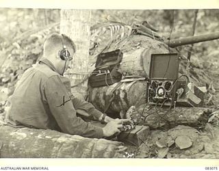 BABIANG, NEW GUINEA. 1944-11-07. TROOPER K. LAMONT, SQUADRON HQ SIGNALS, 2/10 COMMANDO SQN MAKING WIRELESS CONTACT WITH A SECTION OF B TROOP AT LUAIN PLANTATION