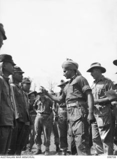 MISSION POINT, NEW GUINEA. 1945-11-09. JEMADAR CHINDT SINGH, INDIAN ARMY, POINTING TO A JAPANESE SOLDIER, AS ONE WHO MISTREATED HIM WHILE HE WAS A PRISONER OF WAR, DURING AN IDENTIFICATION PARADE ..