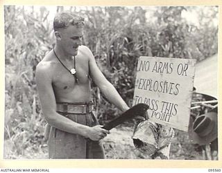 MIVO RIVER, BOUGAINVILLE, 1945-08-29. PRIVATE L.V. HOWARD, 15 INFANTRY BATTALION ERECTING A SIGN AT THE MIVO RIVER FORD. A JAPANESE CAMP WAS ESTABLISHED ON THE EAST BANK OF THE RIVER UNDER THE ..