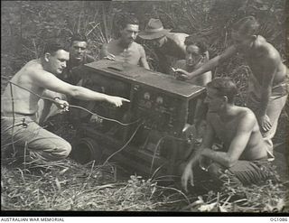 AITAPE, NORTH EAST NEW GUINEA. C. 1944-06. AIRMEN OF NO. 7 MOBILE WORKS SQUADRON RAAF WITH A CAPTURED JAPANESE POWER PLANT WHICH THE ENEMY USED TO LIGHT HIS HUTS AT AITAPE