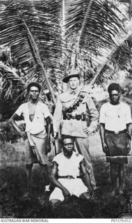 NEW GUINEA. ALAN TRANTER OF THE AUSTRALIAN NAVY AND MILITARY EXPEDITIONARY FORCE (AN&MEF) WITH THREE NATIVES