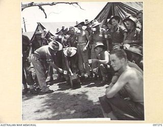 CAPE PUS, NEW GUINEA. 1945-09-29. MEMBERS OF 2/3 INFANTRY BATTALION LINING UP FOR MORNING TEA