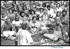View of Ram Dass speaking during his appearance at Andrews Amphitheater, University of Hawaii, one audience member playing an oboe