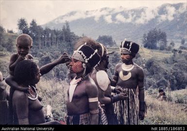 Woman applying face paint to male, Milt timp