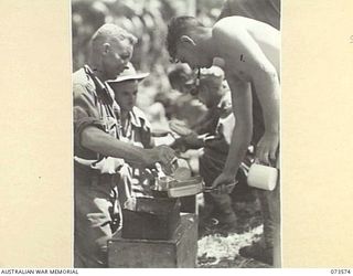 SARANG, NEW GUINEA. 1944-05-25. A MESS PARADE AT B COMPANY, 35TH INFANTRY BATTALION DURING A PAUSE NEAR WEWAK IN THEIR DRIVE UP THE NEW GUINEA COAST. IDENTIFIED PERSONNEL ARE:- NX176262 PRIVATE E. ..