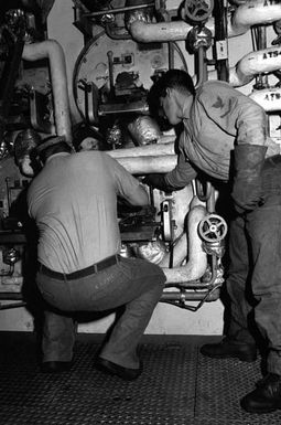 Two sailors aboard the amphibious assault ship USS SAIPAN (LHA 2) begin shutting down one of the ship's boilers for maintenance. The SAIPAN steamed at flank speed for a week to be on station off the coast of Liberia for Operation Sharp Edge