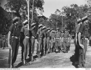 BOUGAINVILLE, SOLOMON ISLANDS, 1944-12-21. MAJOR-GENERAL W. BRIDGEFORD, GENERAL OFFICER COMMANDING 3 DIVISION, (4), ACCOMPANIED BY LIEUTENANT-COLONEL J.H. BYRNE, (3), INSPECTS B COMPANY, 42 ..