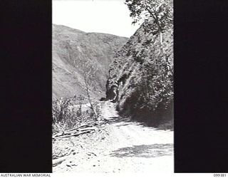 WAU-LABU ROAD, NEW GUINEA, 1945-12-13. THE PRECIPITOUS ANGLE OF THE HILLSIDE WHICH IS COMMON ALONG THE SNAKE RIVER SECTION OF THE ROAD BETWEEN MUMENG AND SUNSHINE. THE AREA IS MAINTAINED BY MEMBERS ..