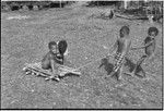 Children playing, pulling a makeshift cart in Tukwaukwa village, Kiriwina