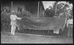 Malakai Veisamasama and European man holding very old piece of tapa cloth