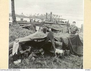 MADANG, NEW GUINEA. 1944-04-24. MEMBERS OF THE 2/15TH FIELD AMBULANCE AT A TWO MAN "DOOVER". IN THE BACKGROUND THE UNITED STATES NAVY MOTOR TORPEDO BOAT 341 LIES MOORED AMONG OTHER CRAFT. ..